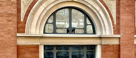 A building with a large arched window and a smaller window below it.