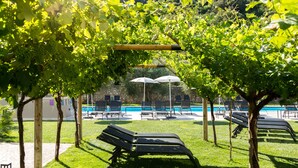 A poolside area with lounge chairs, umbrellas, and a view of a swimming pool. - Aktivhotel Santalucia (Nago-Torbole)