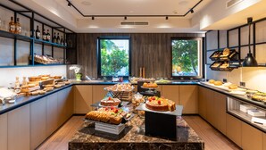 A modern kitchen with marble countertops, wooden cabinets, and a variety of food items displayed on shelves and counters. - Aktivhotel Santalucia (Nago-Torbole)