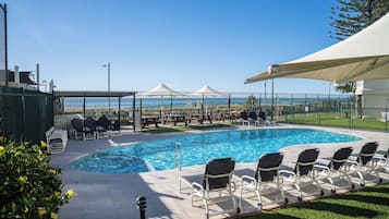 Alberca al aire libre y camastros