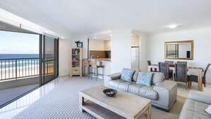 A modern living room with a sofa, coffee table, and a view of the ocean. - The Breakers (Surfers Paradise)