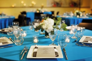 A table set for a formal event with a menu, glasses, and cutlery.
