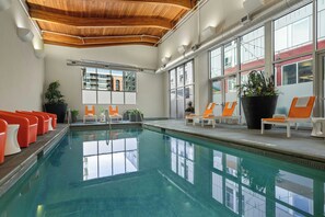 A swimming pool with lounge chairs and potted plants. - Aloft by Marriott Minneapolis (Minneapolis)