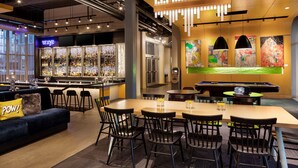 A modern bar area with a pool table, bar stools, and a neon sign. - Aloft by Marriott Minneapolis (Minneapolis)