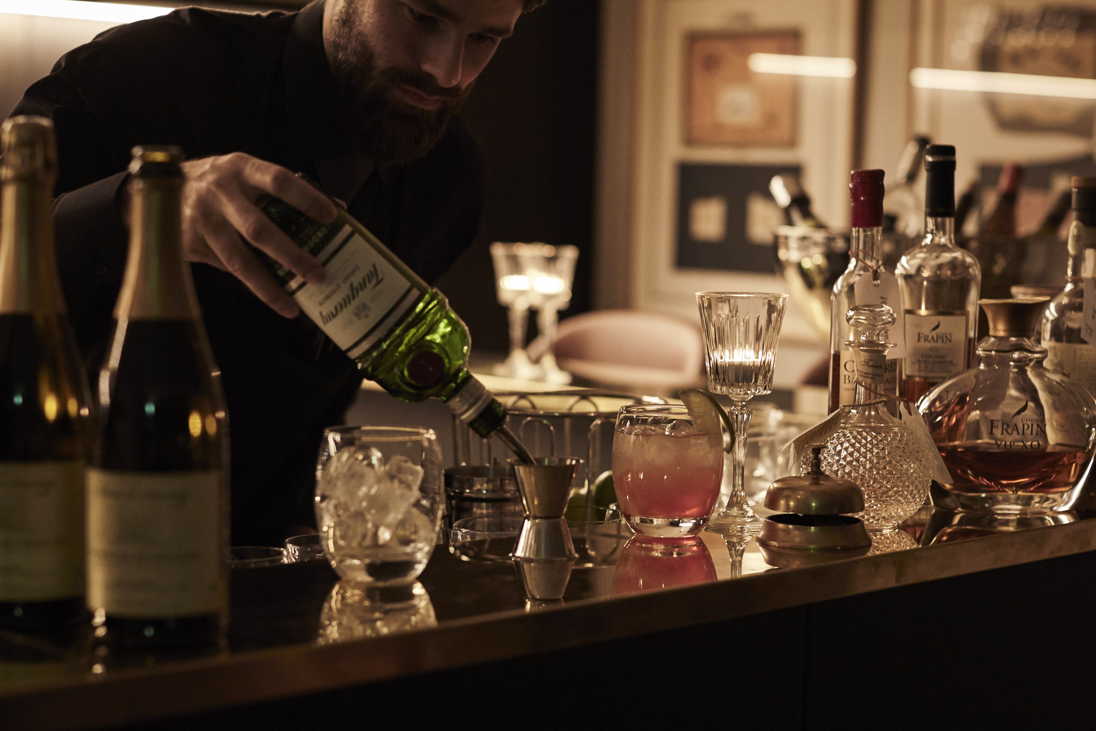 A bar setting with various bottles and glasses, indicating a place for making drinks.