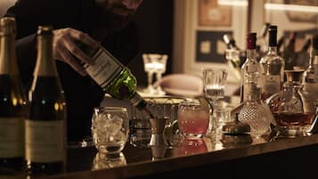 A bar setting with various bottles and glasses, indicating a place for making drinks.