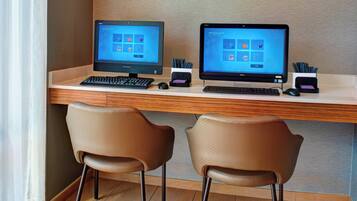 A workspace with two monitors, a keyboard, a mouse, and two chairs.