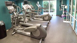 Ein Fitnessstudio mit Laufbändern, Crosstrainern und Trainingsgeräten.