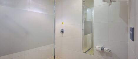 A modern bathroom with a glass shower enclosure, a toilet, and a sink.