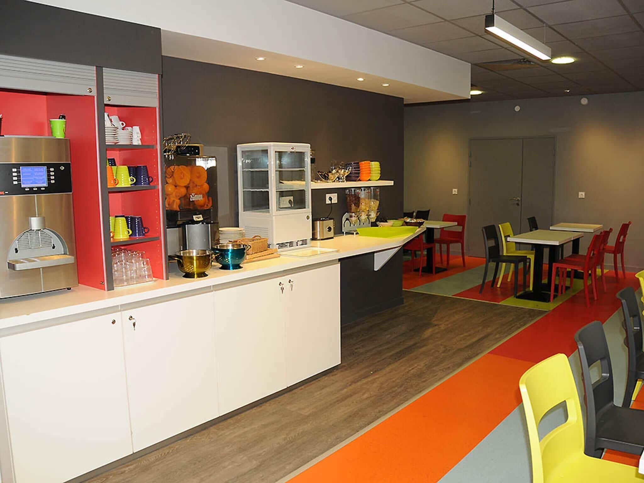 Ein modernes Café mit einer Kaffeemaschine, Regalen voller Tassen und einer Theke mit Spüle.