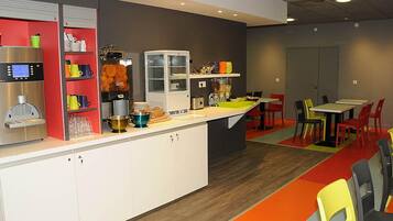 A modern cafe with a coffee machine, shelves with cups, and a counter with a sink.