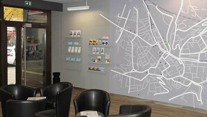 A lobby with a large map on the wall, seating area, and a door leading outside.