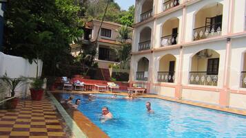 Una piscina al aire libre, tumbonas