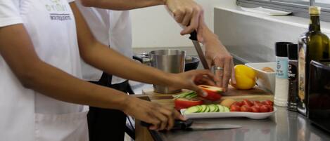 Dos personas preparando comida en una cocina.