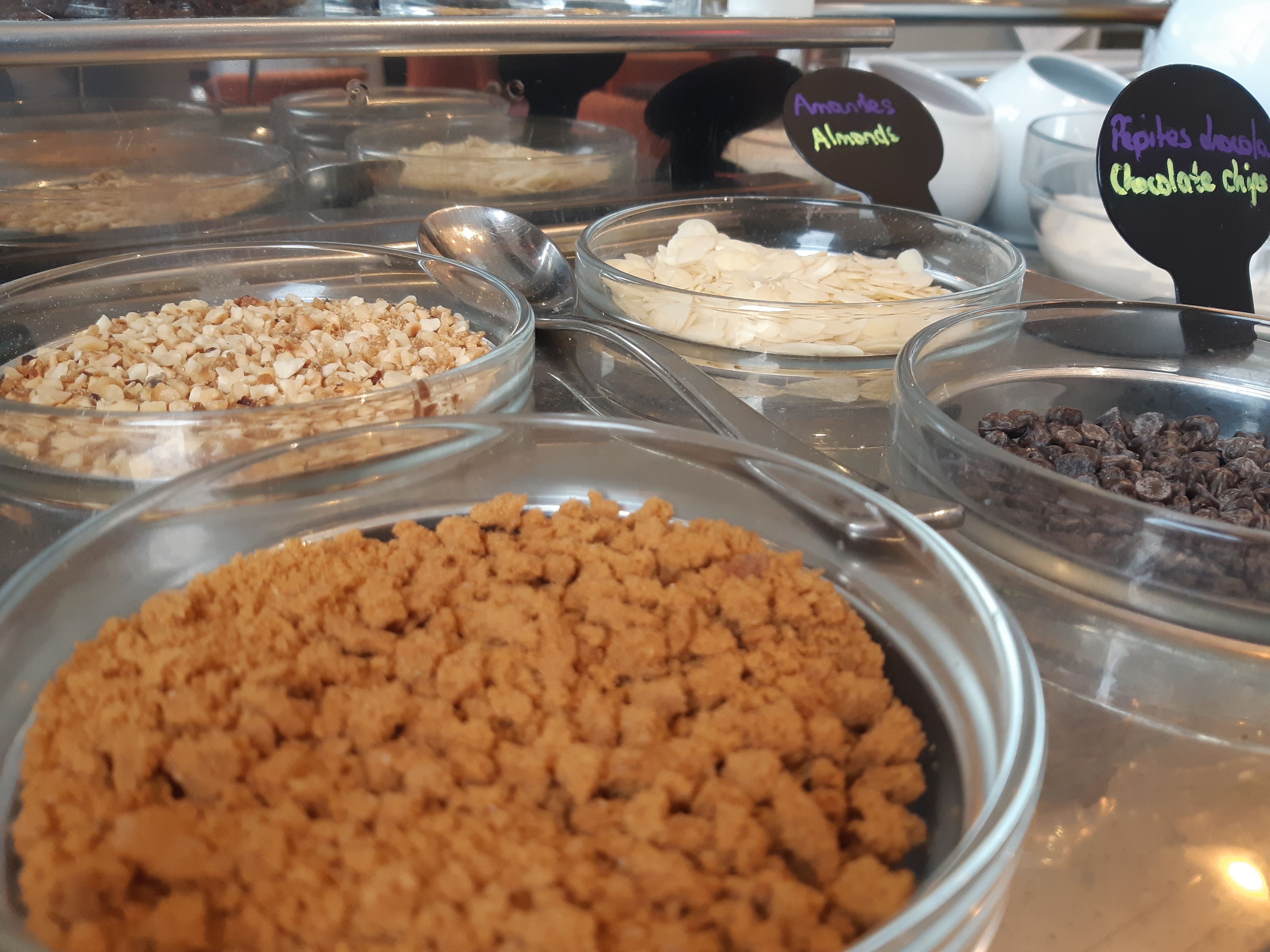 Un assortiment de produits alimentaires présentés sous forme de buffet, comprenant des amandes, des pépites de chocolat et d’autres en-cas.