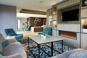 Una sala de estar moderna con chimenea, asientos cómodos y televisor.