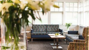 Un espace de détente moderne avec des canapés, une table basse et un vase de fleurs.
