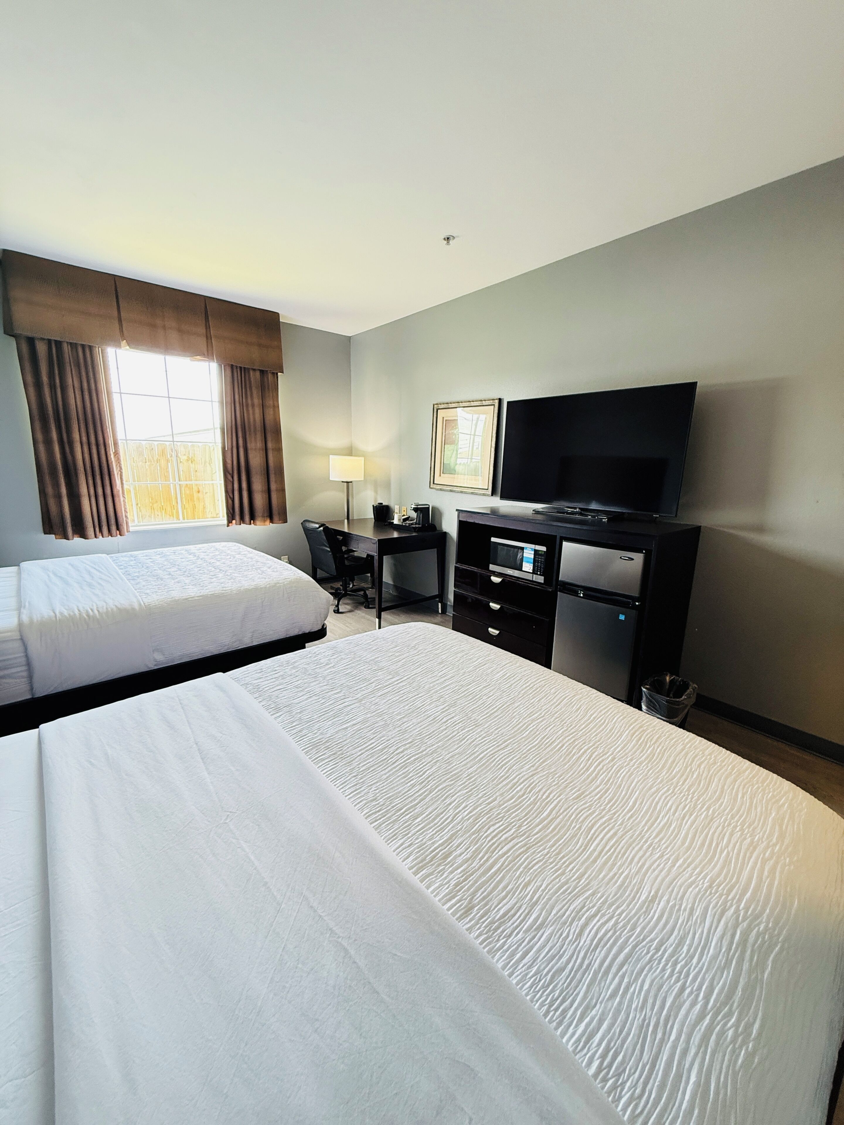 Premium bedding, desk, laptop workspace, blackout drapes