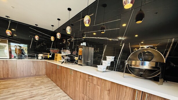 Une cuisine moderne avec des meubles en bois, des appareils en acier inoxydable et des luminaires suspendus.