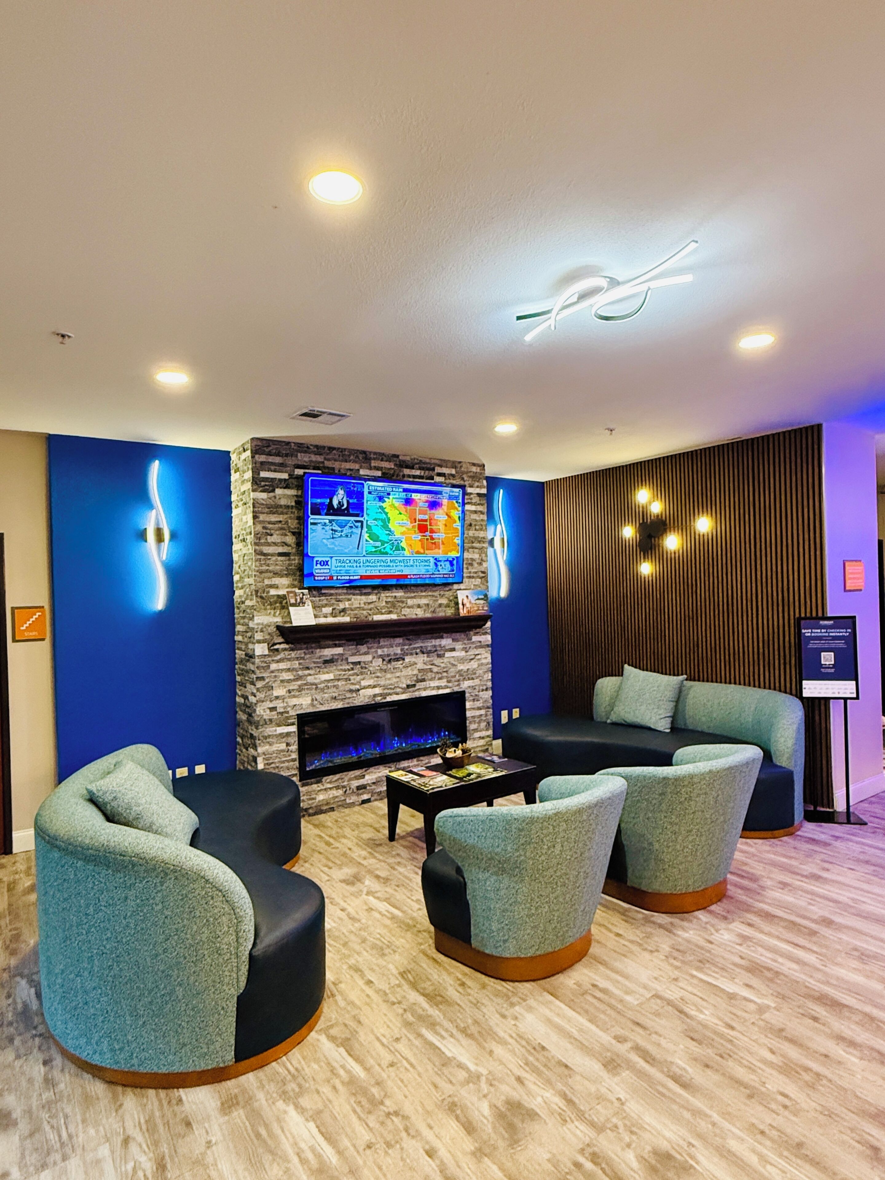 A modern lounge area with a flat-screen TV, a fireplace, and comfortable seating.
