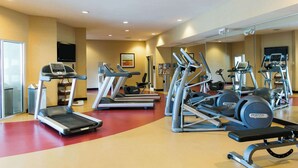 Ein Fitnessstudio mit Laufbändern, Crosstrainern und Gewichte-Bänken.