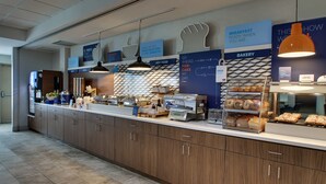 Un buffet de petit-déjeuner proposant une variété d’aliments, notamment des viennoiseries et des plats chauds.