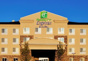 A Holiday Inn Express & Suites building with a prominent green and white logo, multiple windows, and a stone facade. - Holiday Inn Express & Suites Waukegan by IHG (Waukegan)