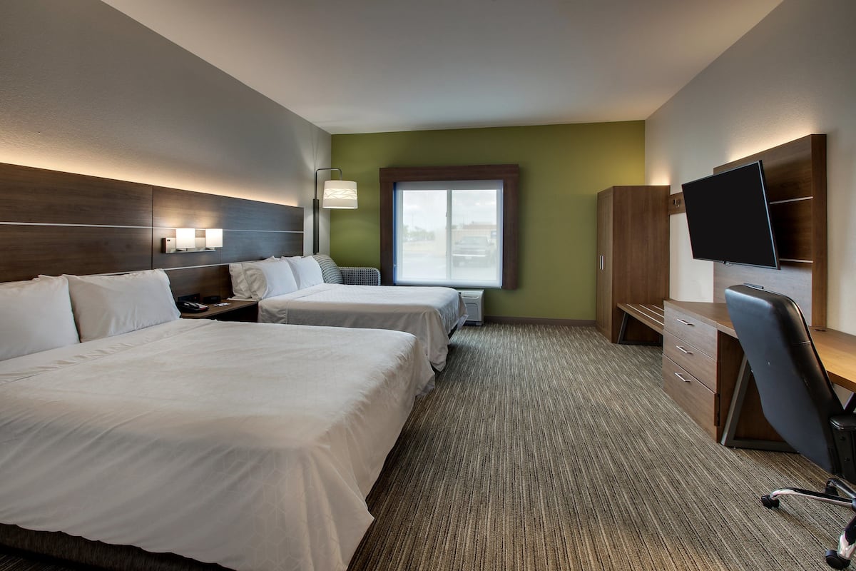 Two double beds with white linens, flat-screen TV, and wardrobe.