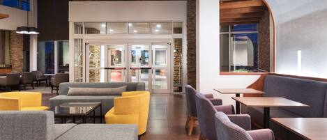 A modern lobby with seating areas, a reception desk, and a stone accent wall.