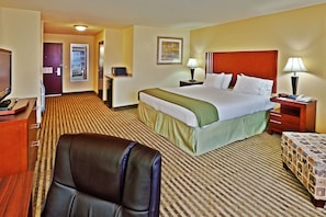 A hotel room with a large bed, a desk, a chair, a TV, and a lamp. - Holiday Inn Express & Suites Ponca City by IHG (Ponca City)