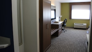 Hotellihuone, jossa on työpöytä, tuoli ja suuri ikkuna.