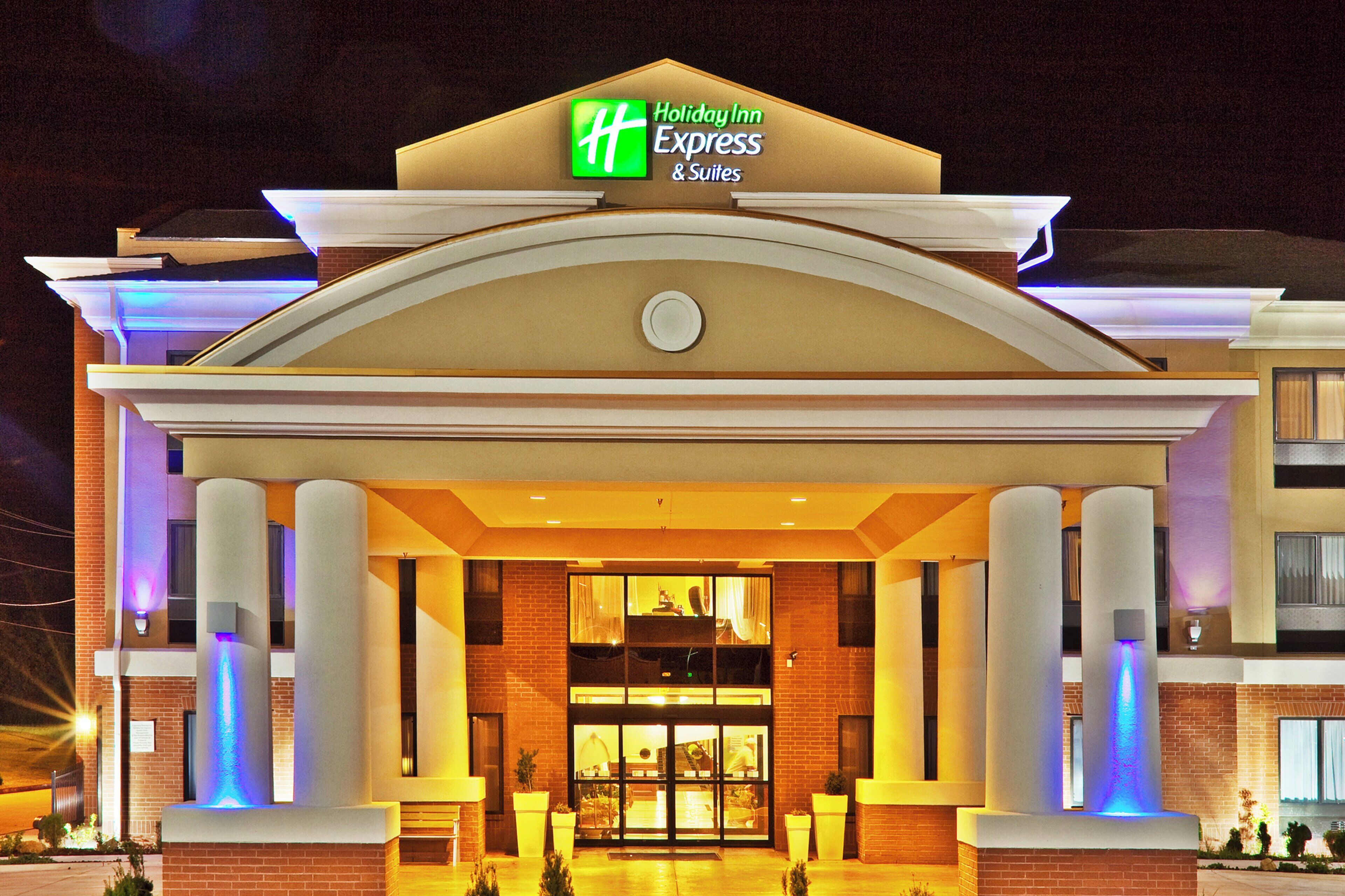 L’entrée d’un hôtel Holiday Inn Express & Suites, avec une enseigne bien visible, de grandes colonnes et une entrée accueillante.