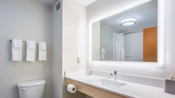 A modern bathroom with a toilet, a sink, and a mirror.