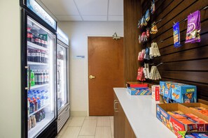 Een automatenhoek met snacks en een koelkast vol drankjes.