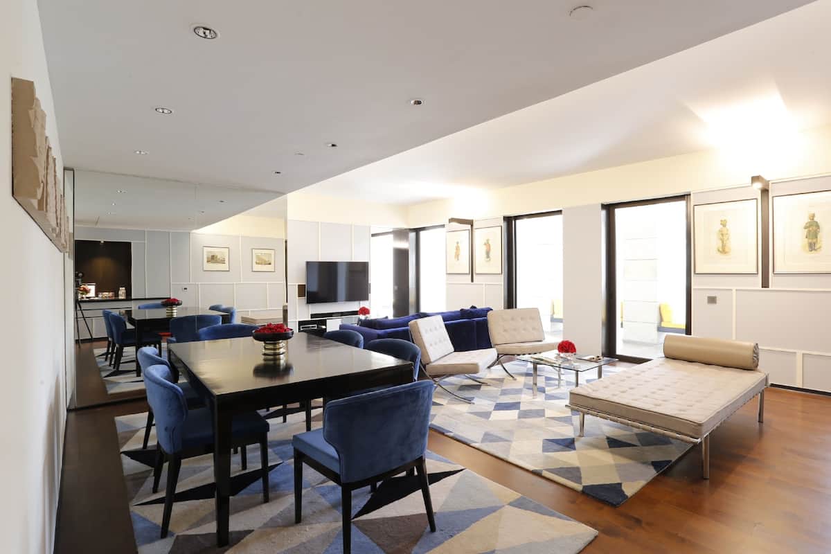 A modern living room with a dining area, featuring a sofa, a coffee table, and a TV.