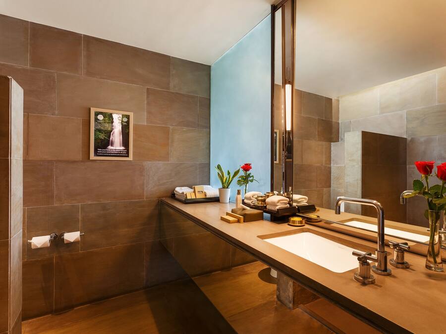 Un baño moderno con un espejo grande, dos lavamanos y una zona de tocador.
