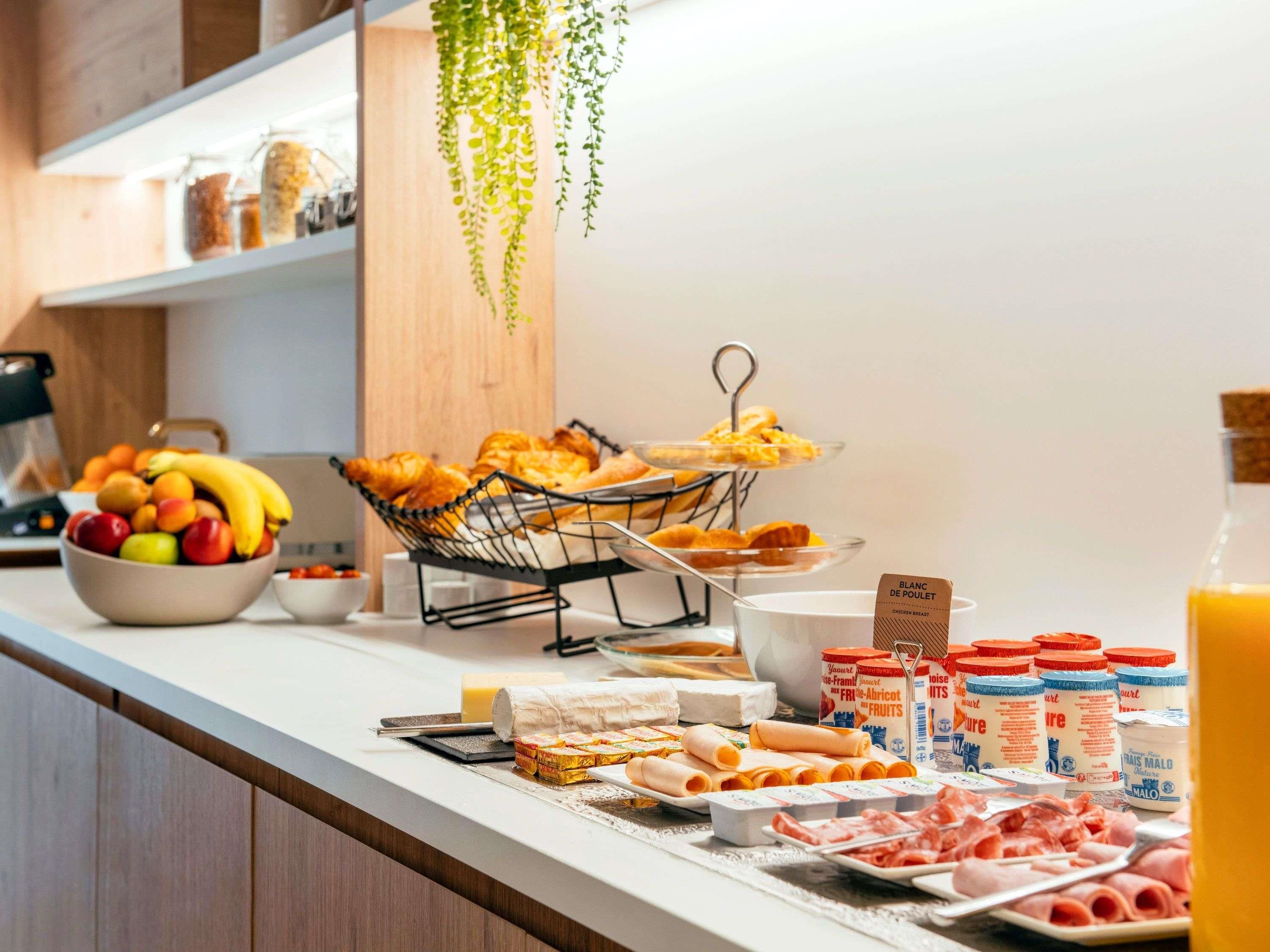 A breakfast buffet with fruits, pastries, and various dairy products.