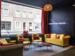 Un intérieur moderne avec un canapé, des fauteuils et un tapis à motifs.