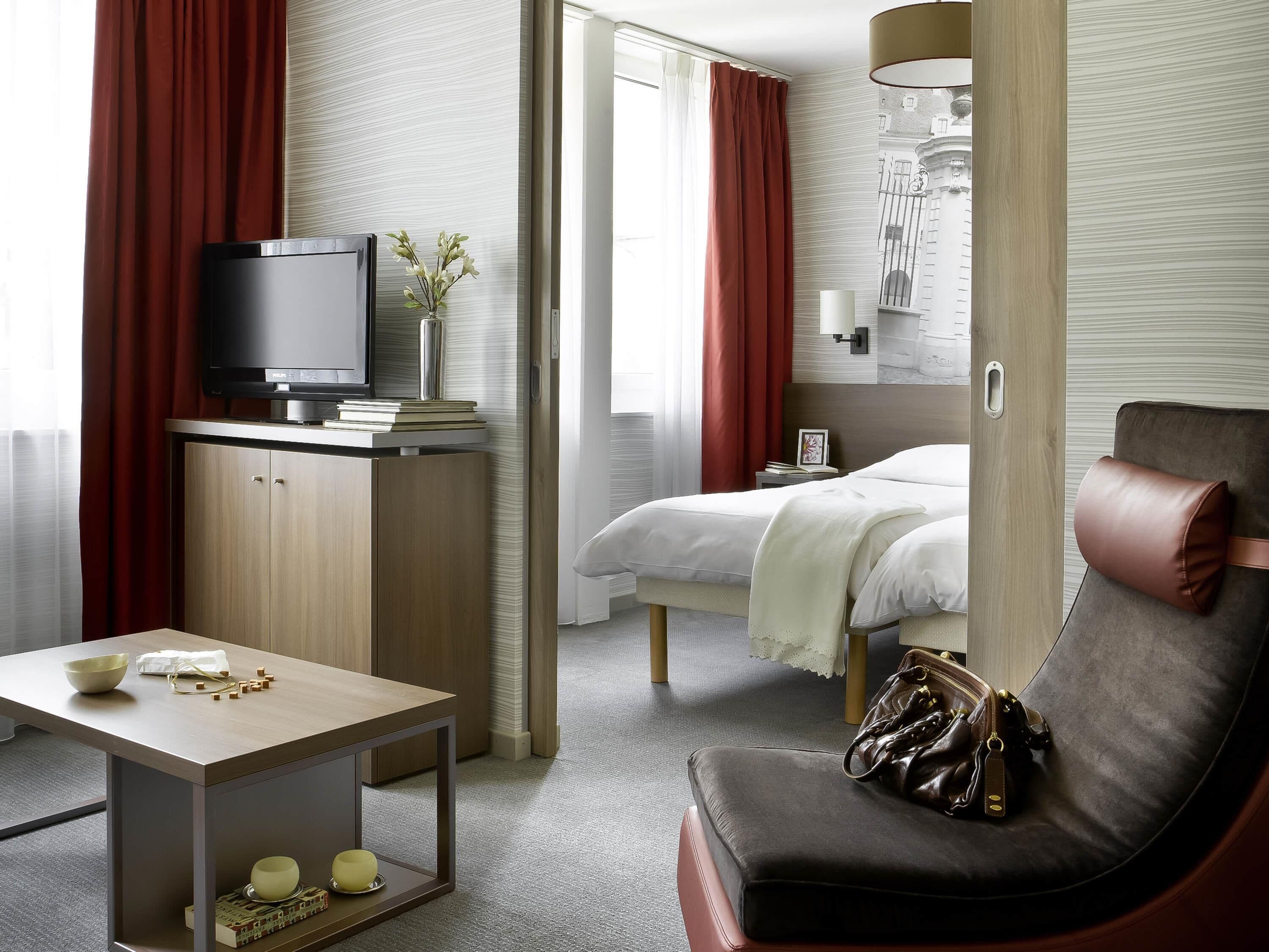 Une chambre d’hôtel avec un lit, une télévision, un bureau et une chaise.