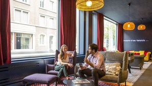 A modern interior with a sofa, armchairs, a coffee table, and a patterned rug. - Aparthotel Adagio Basel City (Basel)