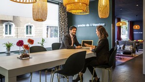 A modern meeting room with a long table, black chairs, and decorative hanging lights. - Aparthotel Adagio Basel City (Basel)