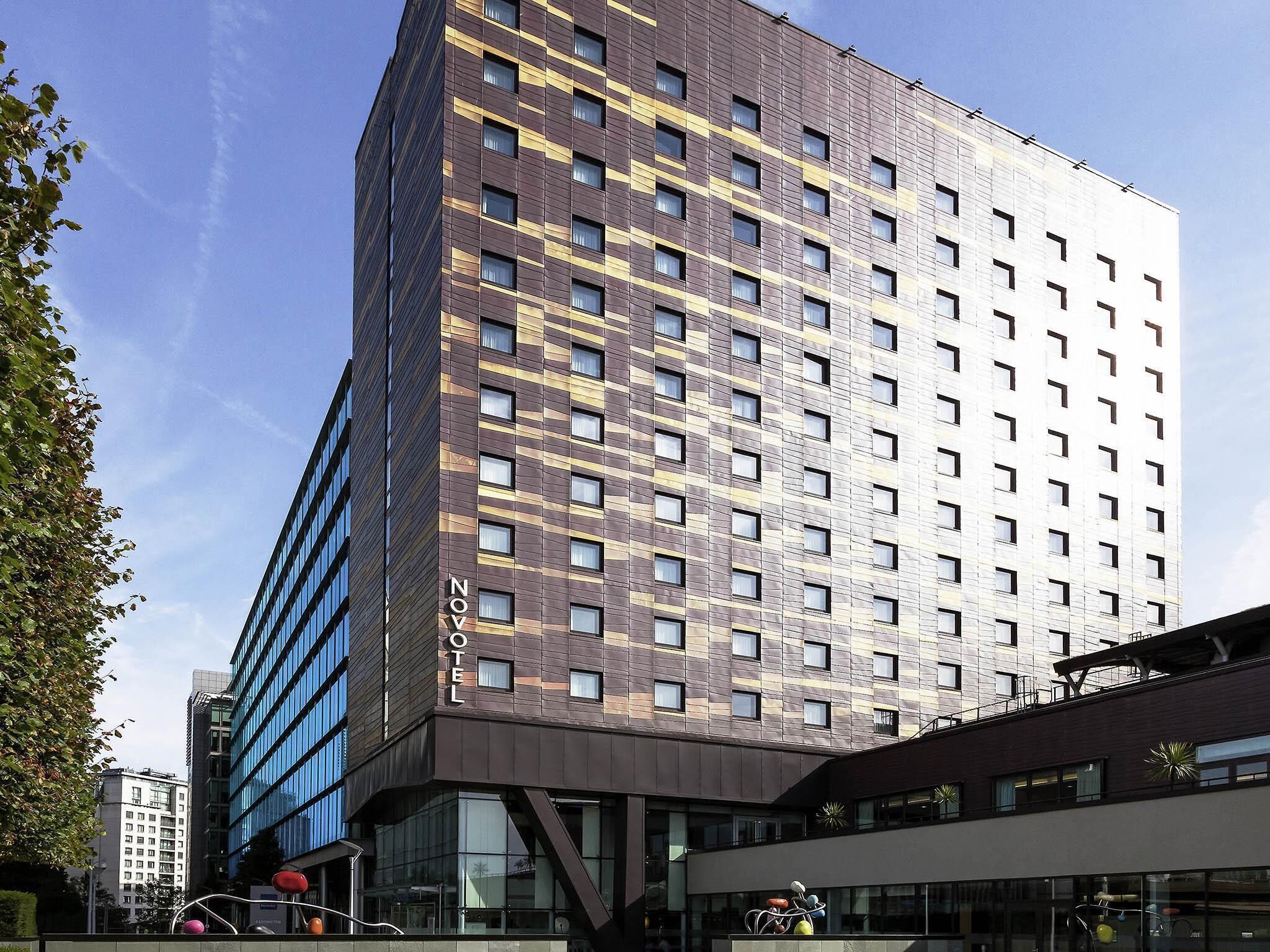A modern hotel with a unique facade, multiple floors, and a prominent 'NOV' sign.