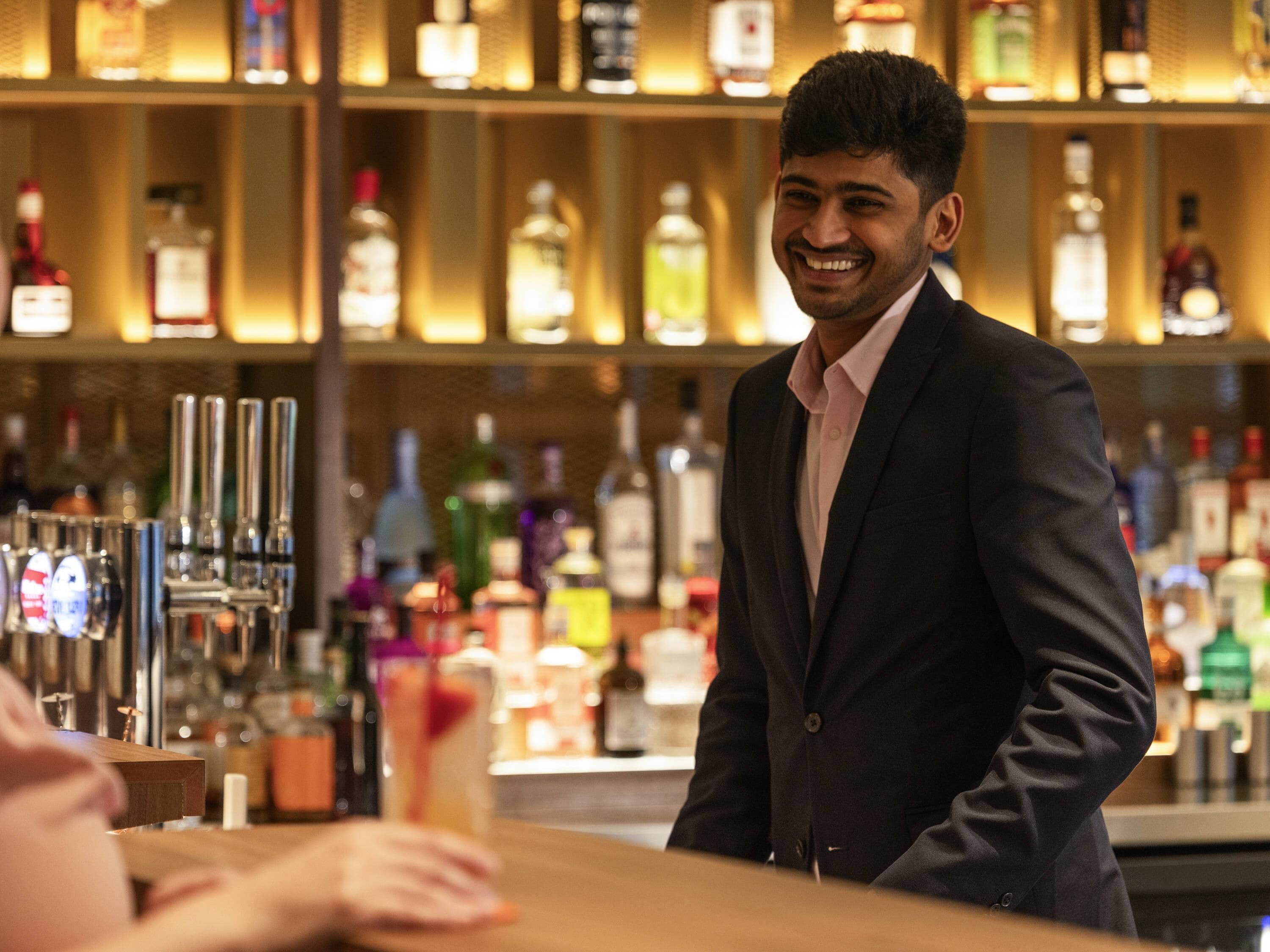 Een barscène met een barman en een klant.