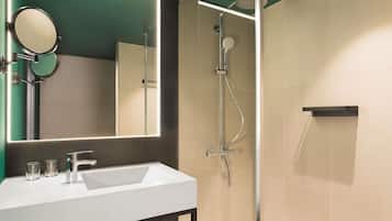 A modern bathroom with a white sink, a mirror, and a shower.