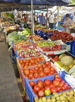A market stall with various fruits and vegetables displayed in crates.