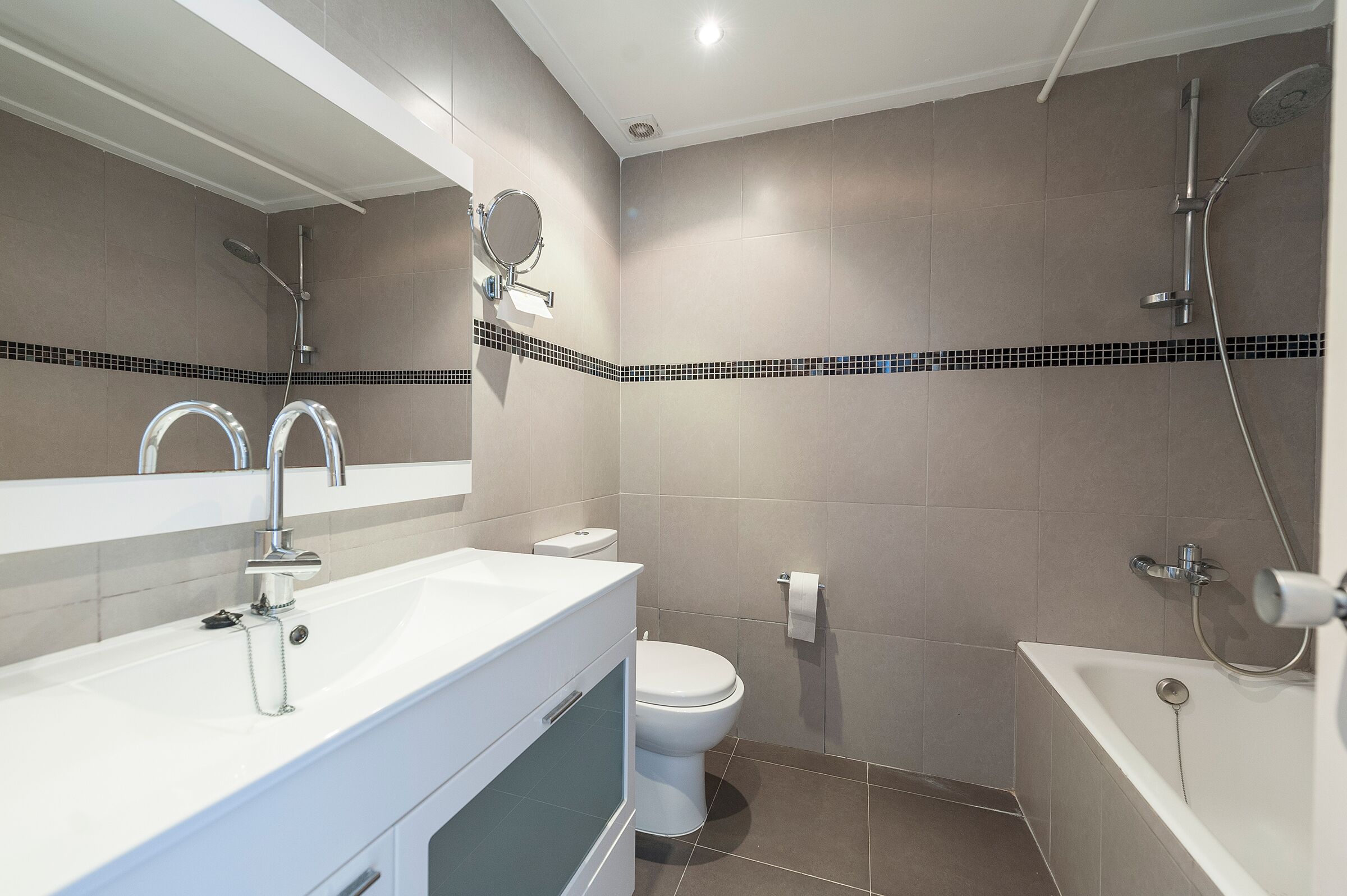 Un baño moderno con lavamanos, inodoro y bañera.