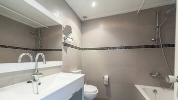 Un baño moderno con lavamanos, inodoro y bañera.
