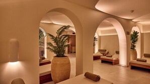 Un espace spa comprenant des sièges, une grande plante et un comptoir d’accueil.