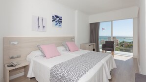 A hotel room with a bed, bedside table, and a view of the sea. - Hotel Timor (Palma de Mallorca)