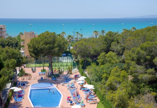 Una piscina techada, una piscina al aire libre de temporada, sombrillas